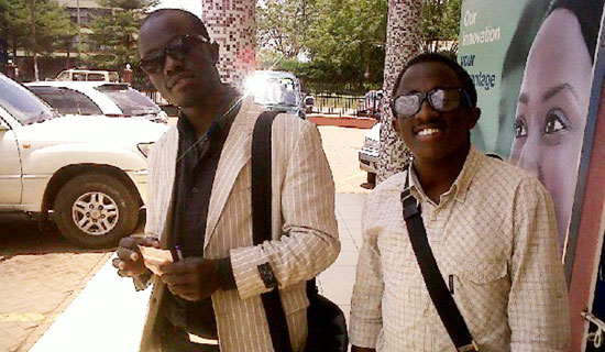 Cricket star Kyobe (right) with fan, Mugabi.   PHOTO BY ISAAC SSEJJOMBWE