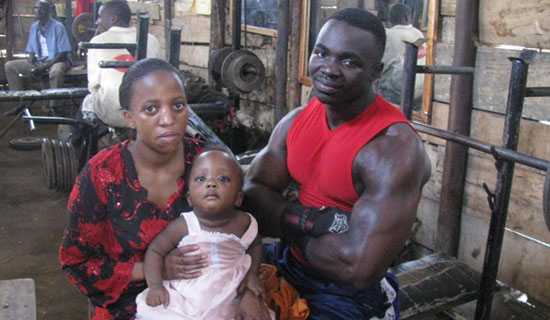 Cobra i s back on his feet after the 2010 shooting. He poses with his wife and child in his gym.  PHOTO BY JUDE KATENDE