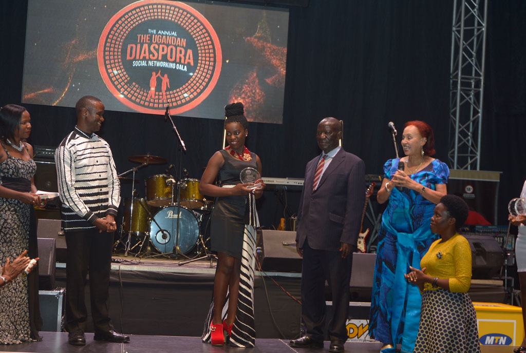 Vice President Edward Kiwanuka Ssekandi (Suit) hands over the Uganda Diaspora Life time Achievement Award to King and Queen of Katwe actress Ms. Phiona Mutesi and coach Robert Katende flanked by his wife  in recognition for their role in marketing Uganda abroad through their film during the 6th Diaspora Gala and social networking dinner at Serena Kampala hotel.