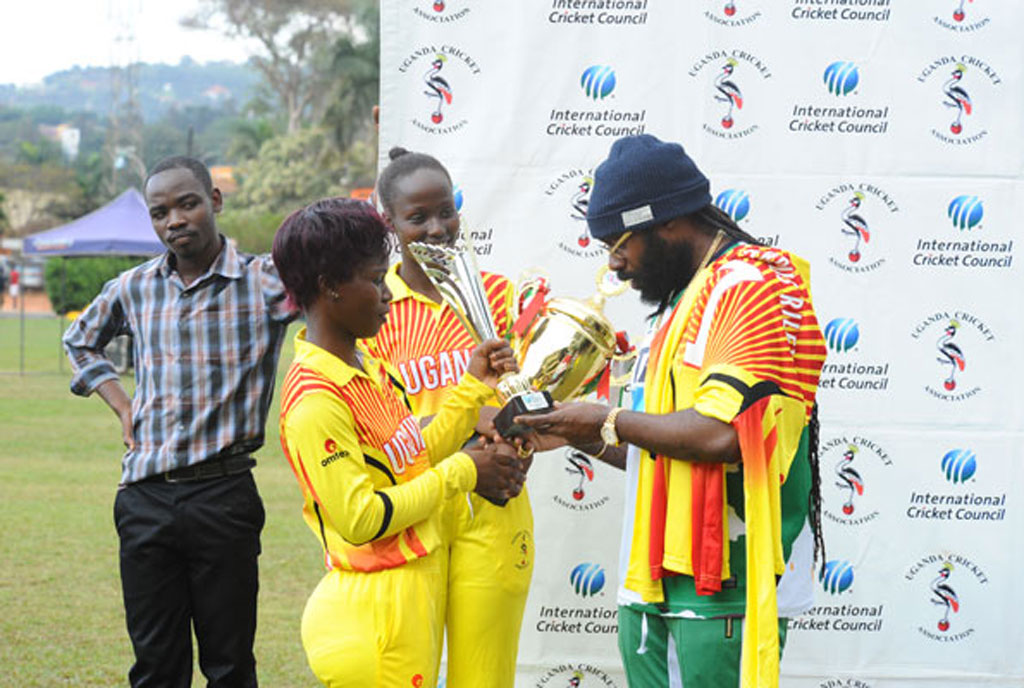 Jamaican Reggae star Riley (R) admires trophies presented to her by the Lady Cricket Cranes skipper Kevin Awino (L) and Janet Mbabazi (C) at the end of the Tarrus Riley Cricket Carnival in Lugogo yesterday