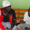 Football striker Robert Ssentongo and his fan Jacob discuss football. PHOTO BY ISAAC SSEJJOMBWE