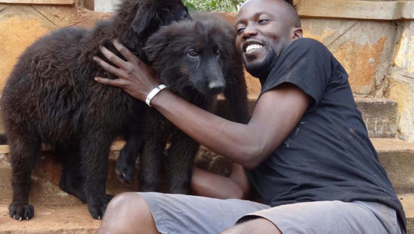 Rwothomio with some of his dogs. PHOTO BY ISAAC SSEJJOMBWE