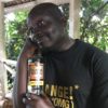 Dibo Nakuzambwa Brown poses with a photo of Uganda Waragi Pineapple flavour