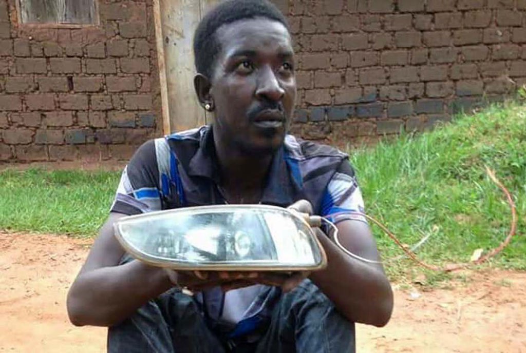 Qute Kaye holding teh headlight he allegedly stole from a car in Busega on Thursday